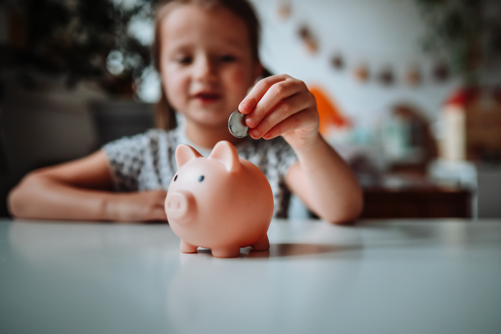 Future Finance: Girl Child Taking the First Steps in Financial Responsibility, Saving in the Piggy Bank.